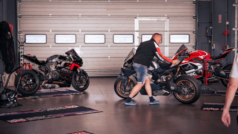 garage de motos avec une mécanicien qui en déplace une