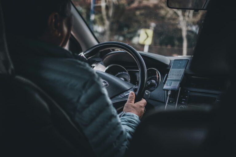 femme conduisant une voiture en utilisant un système de localisation GPS sur son téléphone portable